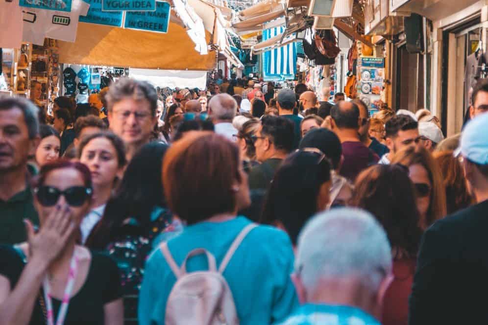 Crowded streets in a marketplace somewhere in Europe. As the industry returns to normalcy, consider your health and safety during travel after coronavirus.